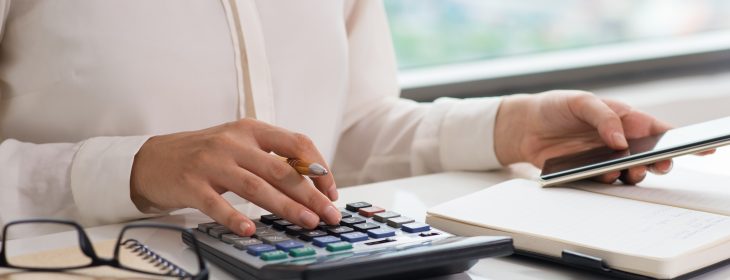 fechar-se-da-mulher-usando-calculadora-e-telefone-inteligente